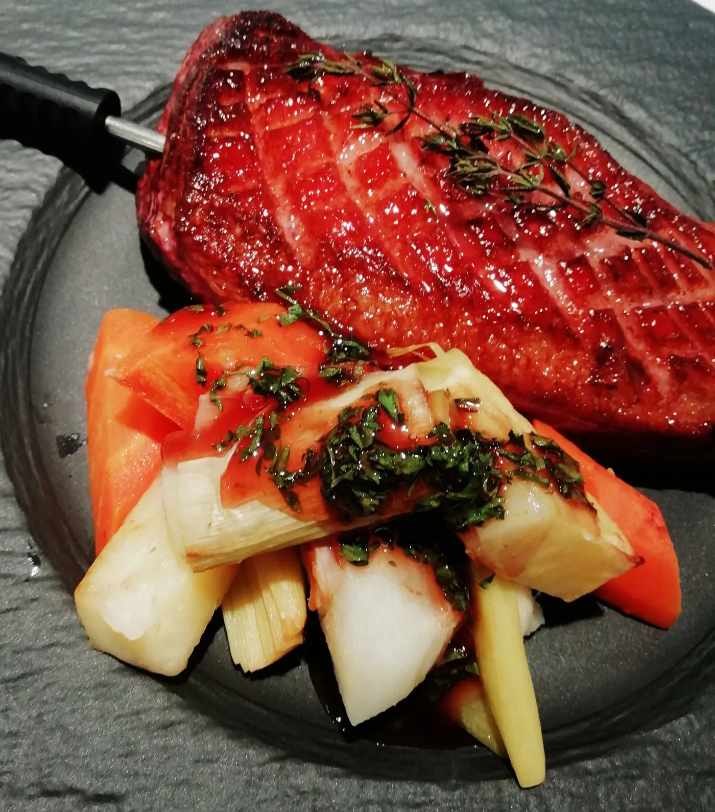 Assiette dressée : pièce laquée, légumes croquants et herbes